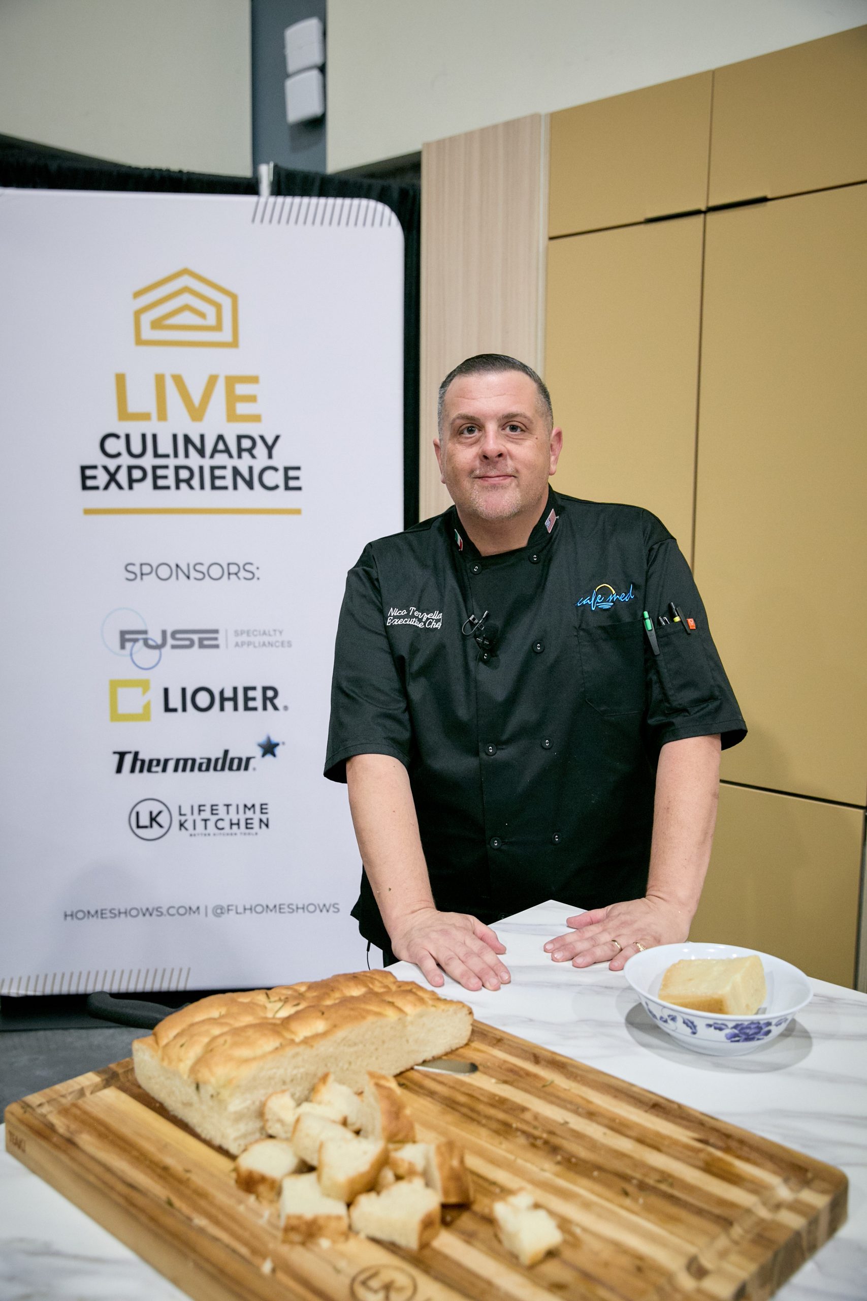 Chef presenting a freshly baked dish during the Live Culinary Experience at the Home Design and Remodeling Show.