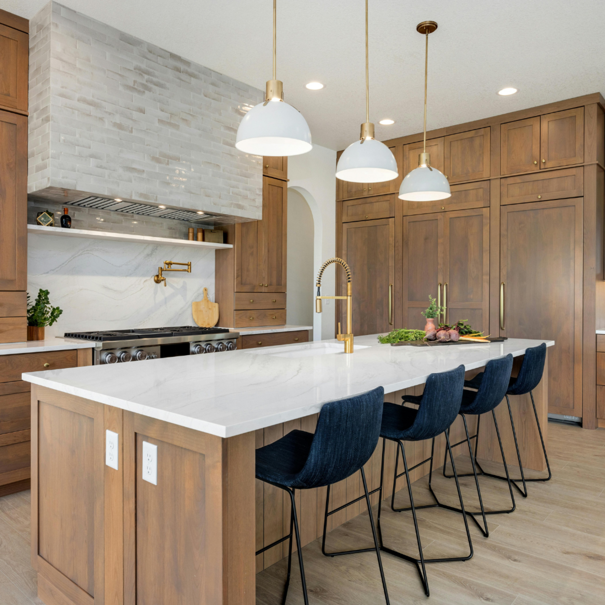 Contemporary kitchen with wood cabinetry and pendant lighting displayed at the Home Design and Remodeling Show.