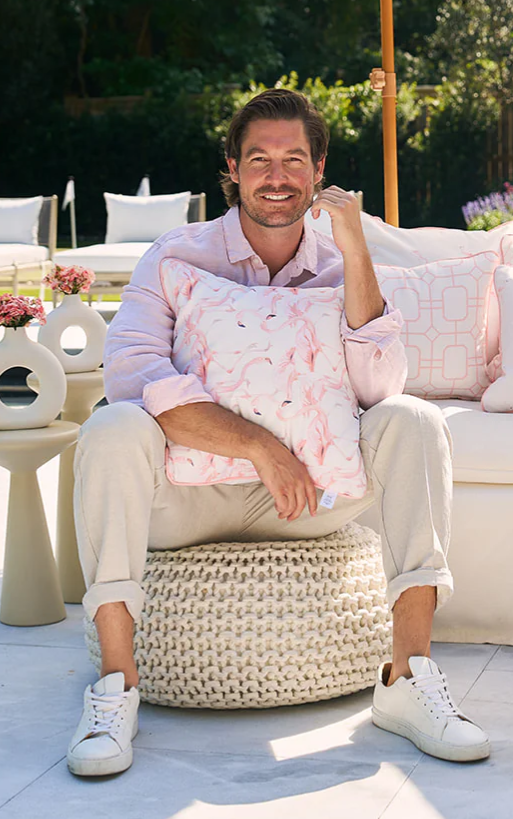 Man in a pink shirt smiling while seated during the Home Design and Remodeling Show VIP event.