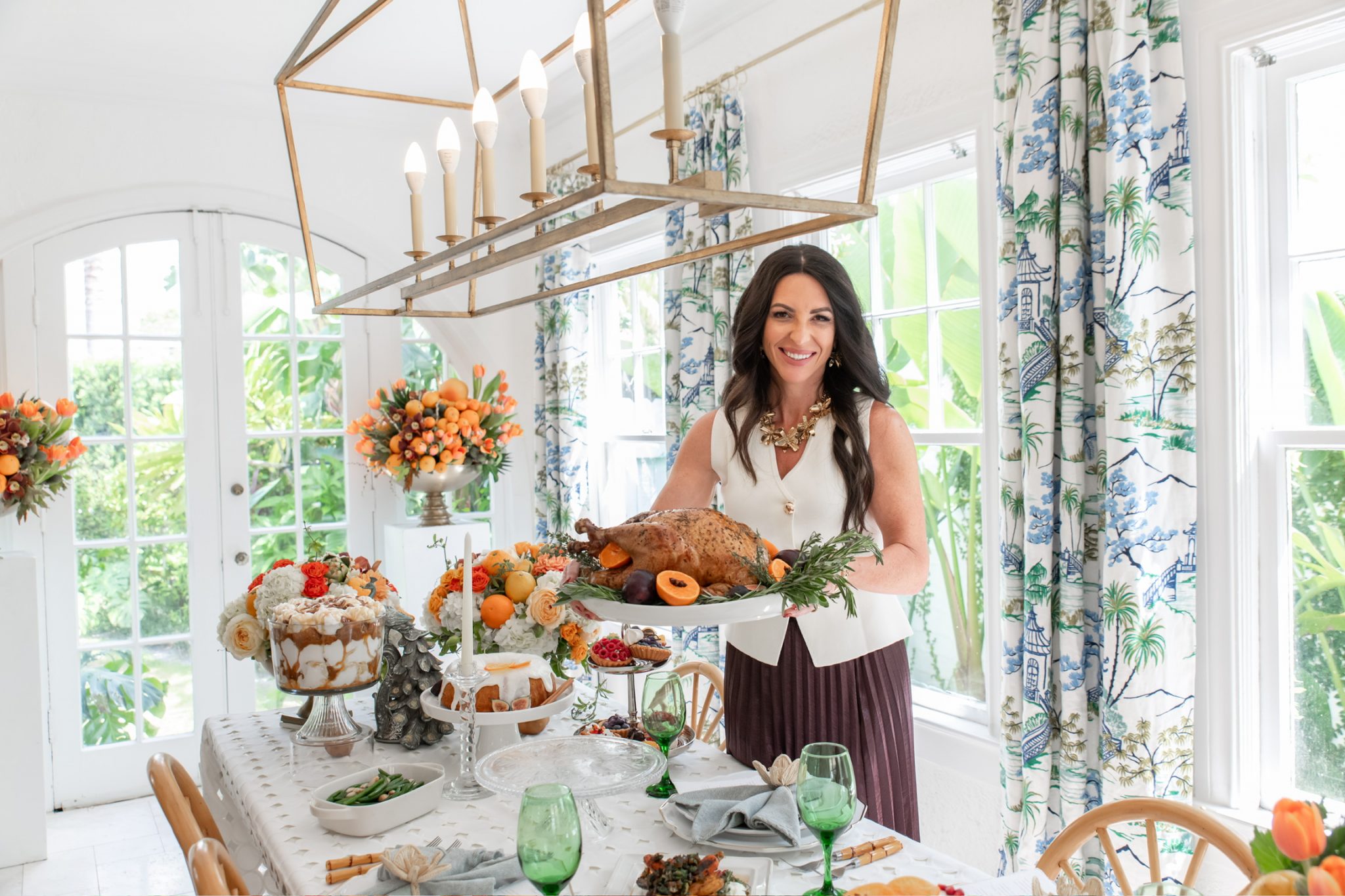 Woman arranging flowers and decor in a bright, stylish setup at the Home Design and Remodeling Show.