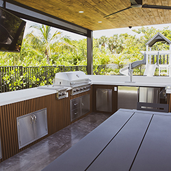 Outdoor kitchen and dining space with modern wood finishes showcased at the Home Design and Remodeling Show.
